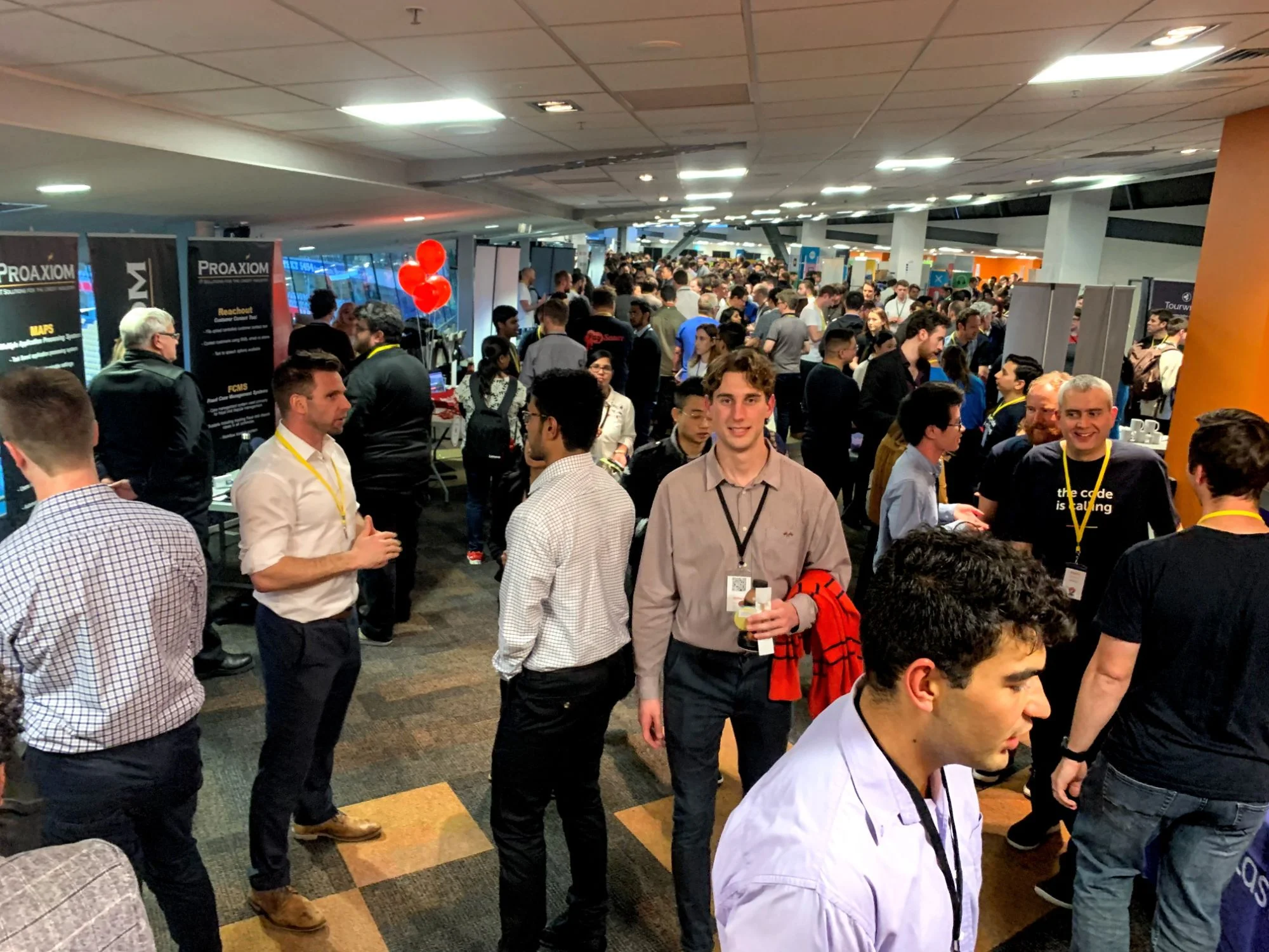 A crowded Summer of Tech career fair with attendees mingling among sponsor booths