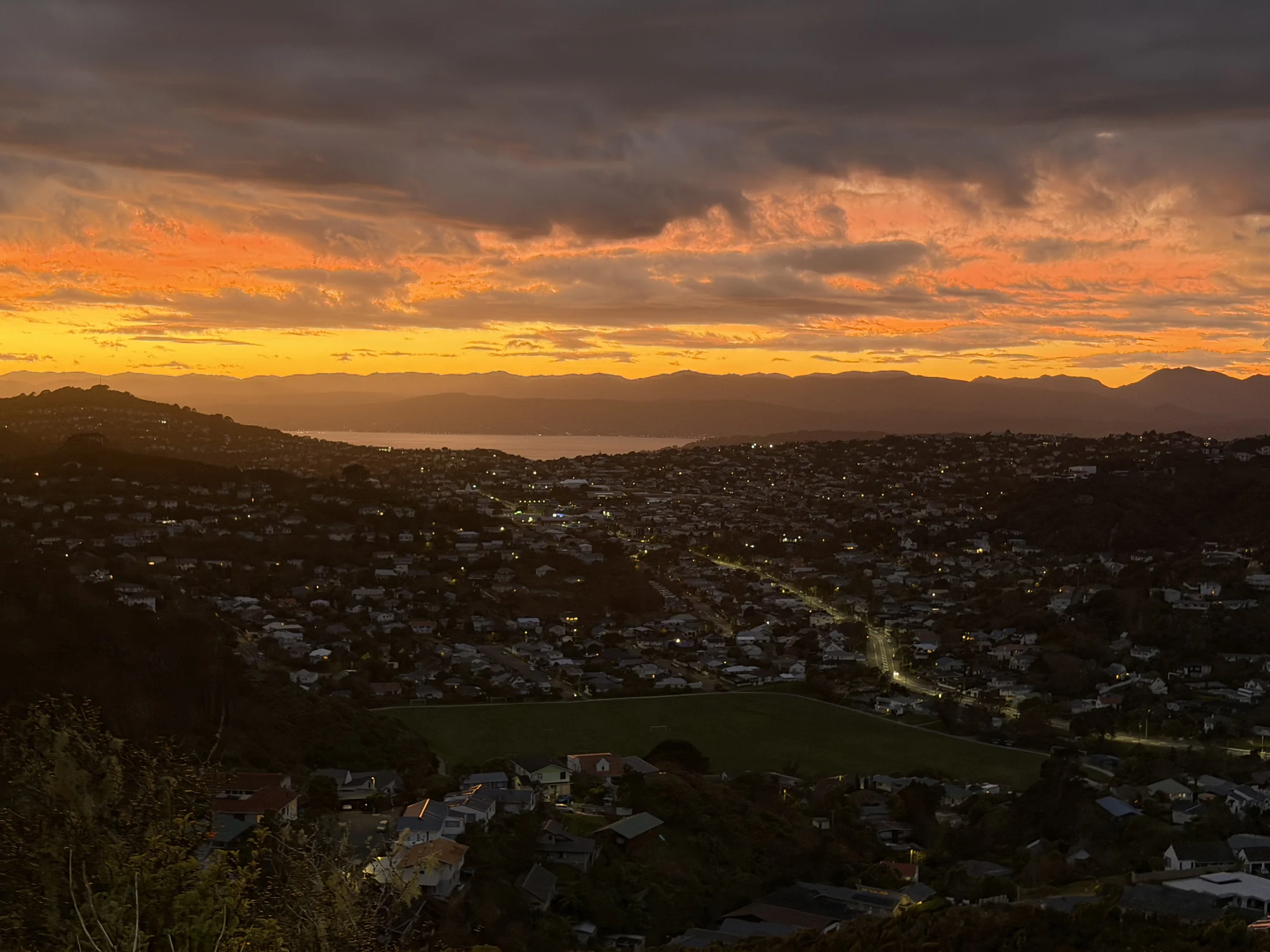 A dramatic orange sunrise over the hills and suburbs of Wellington