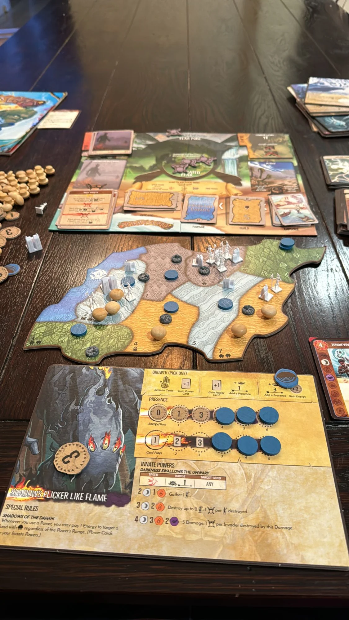 A game of Spirit Island set up on a dining table, mid-play